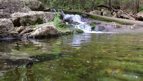 With-sped-up-water,-creek-waterfall-flowing-into-large-pool-below