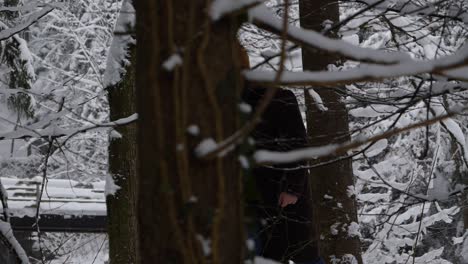jóvenes europeos del este caminan por los bosques nevados vestidos de invierno con su cámara negra
