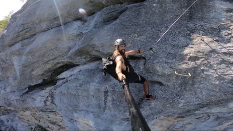 man climbing a mountain via ferrata