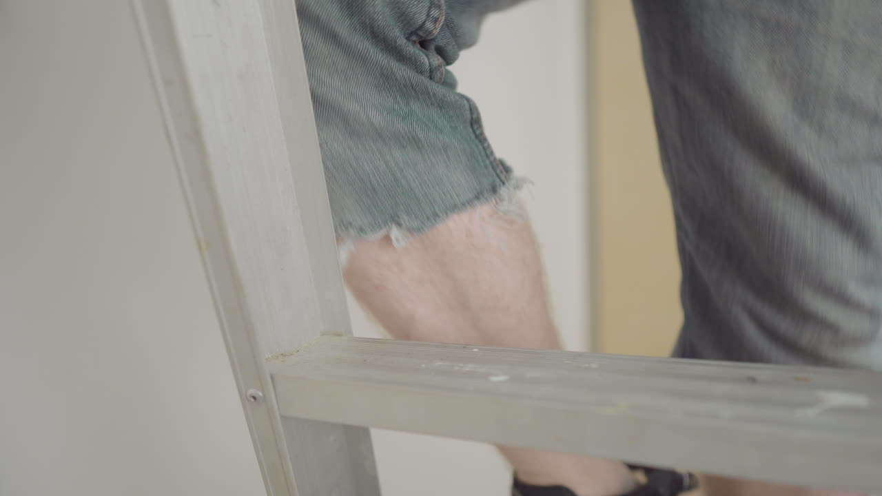 el hombre agarra rápidamente el martillo y sube la escalera