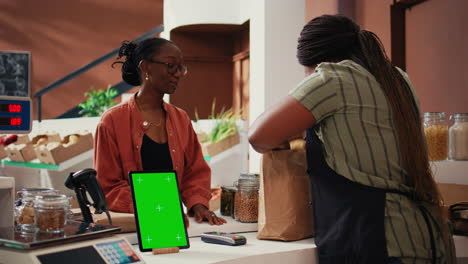 Frau-Nähert-Sich-Der-Kasse-Mit-Greenscreen-Auf-Dem-Tablet