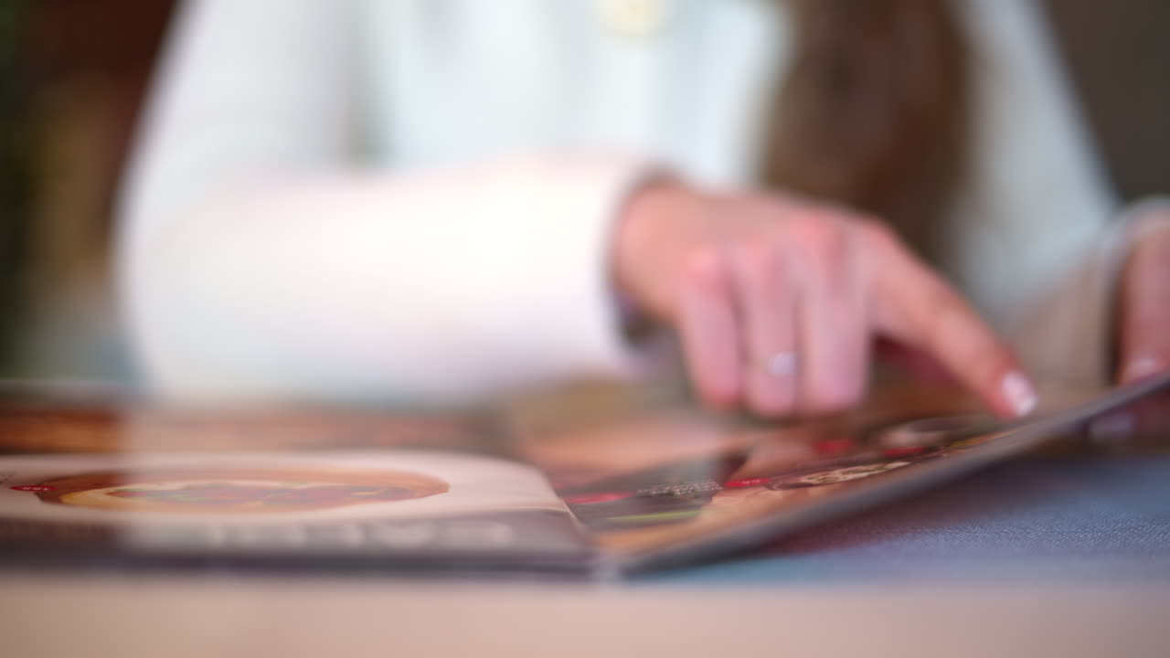 Woman hands in restaurant choosing food in menu