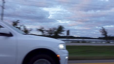 Shot-while-driving-along-a-lakeside-road-on-the-asphalt-road-on-a-cloudy-day