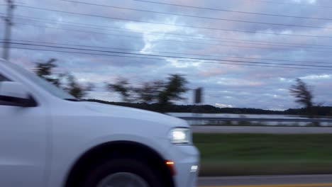 baleado mientras conducía por una carretera junto al lago en la carretera asfaltada en un día nublado