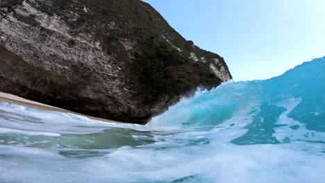 toma en cámara lenta extrema de estar dentro del barril de una gran ola en la playa de kelingking, en la isla de nusa penida, bali, indonesia