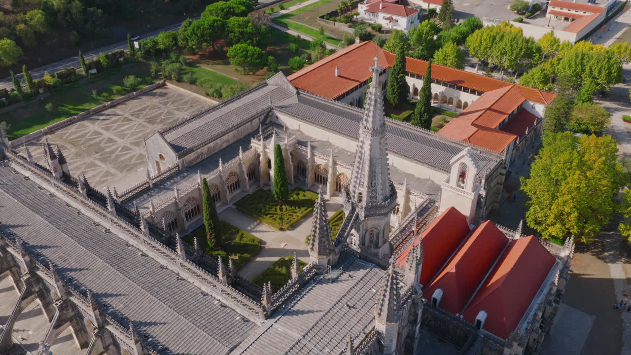 Mosteiro da Batalha aerial orbit counterclockwise, medium‑wide shot centered on Founders’ Chapel pinnacles