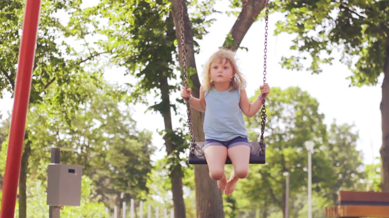 A Little Girl Swinging In The Park, Slow Motion, Hot Summer Day, Low Angle  Free Stock Video Footage Download Clips Family