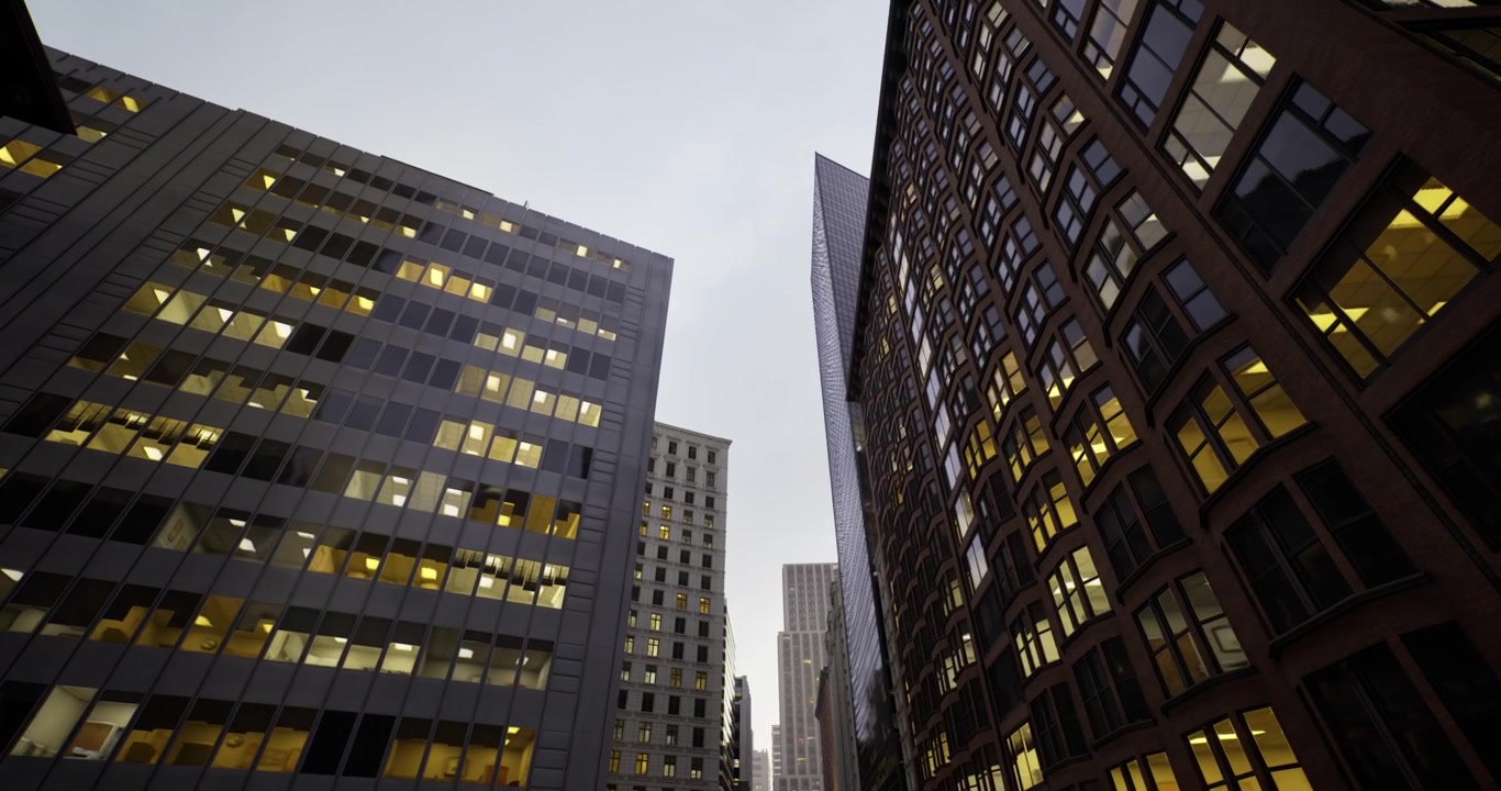 Skyline serale con profilo urbano illuminato dalle calde luci degli uffici