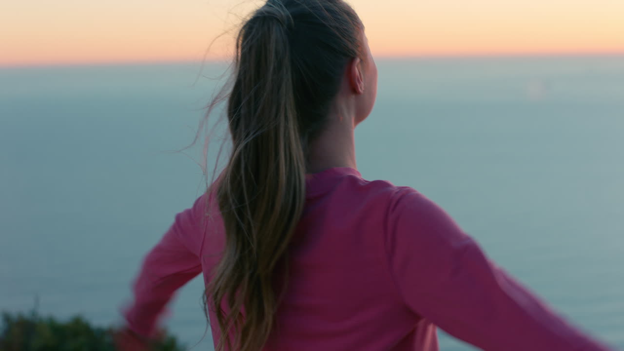 mujer feliz con los brazos levantados en la cima de la montaña disfrutando de la libertad celebrando el logro niña mirando la hermosa vista del océano al atardecer