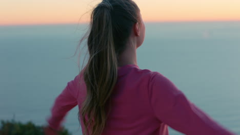 mujer feliz con los brazos levantados en la cima de la montaña disfrutando de la libertad celebrando el logro niña mirando la hermosa vista del océano al atardecer