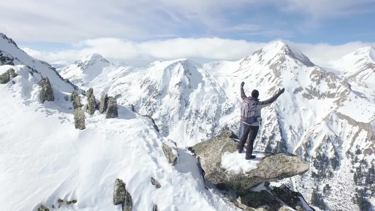 excursionista en la cumbre de la montaña en un paisaje nevado