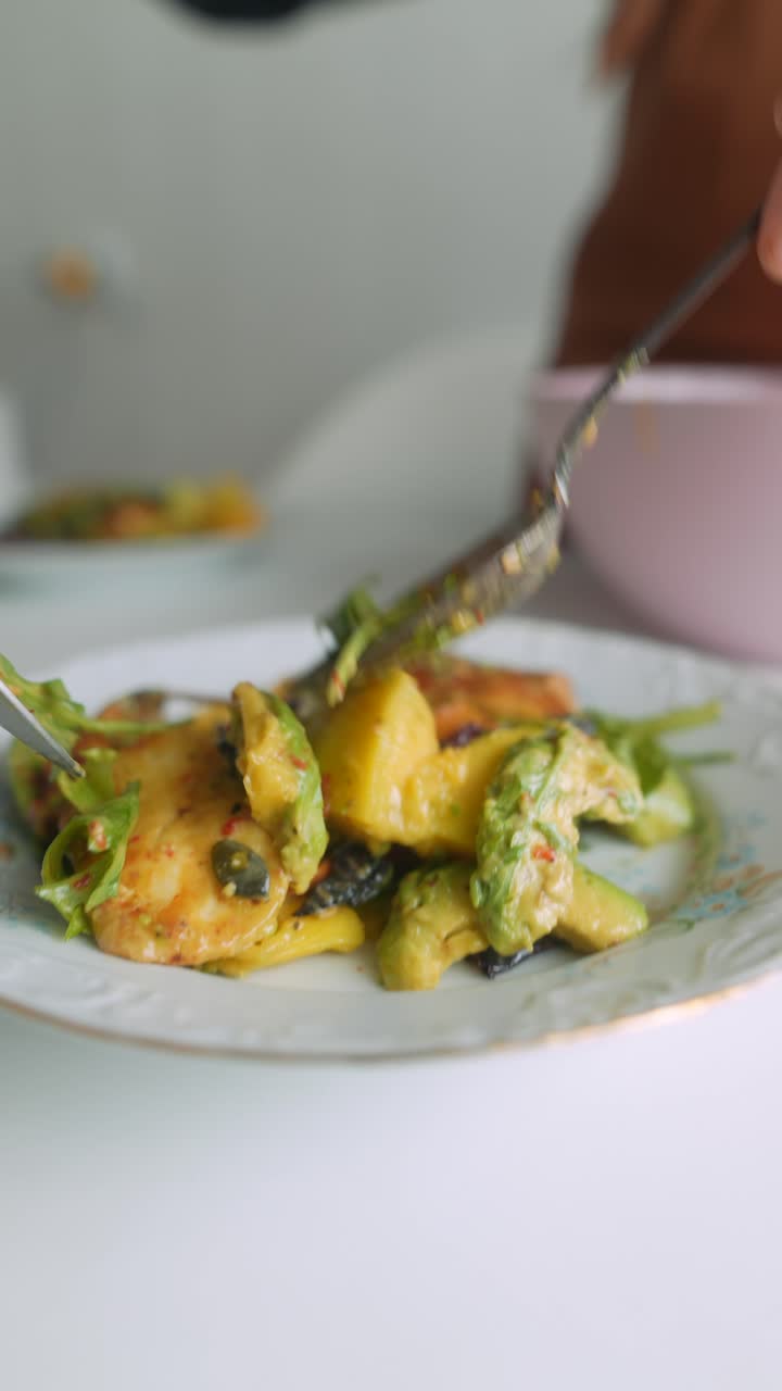 Woman Serving Fresh Healthy Salad with Avocado and Mango