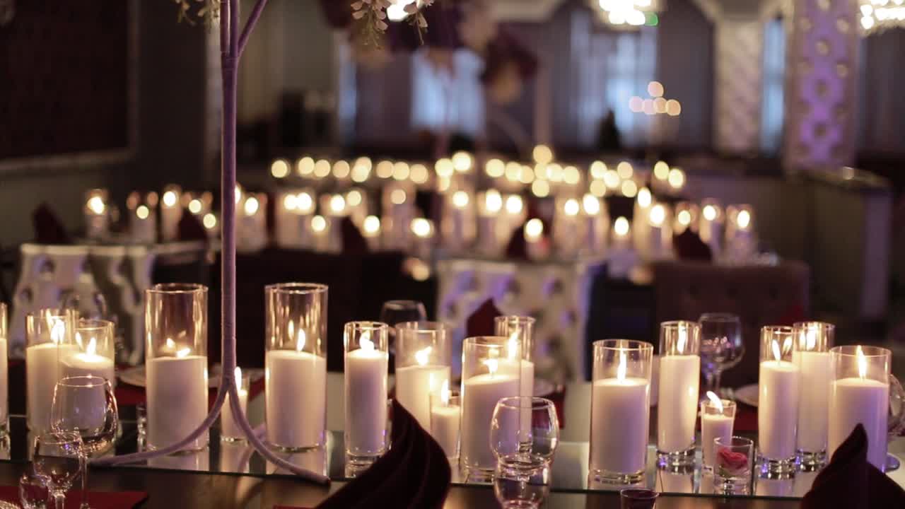 Tavolo apparecchiato per una festa, un evento o un ricevimento di matrimonio. Candele decorative accese su un tavolo da banchetto.