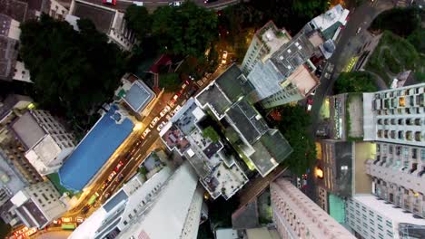 aerial 4k drone top down bird's eye view over hong kong dense city skyscrapers and busy streets, in the evening