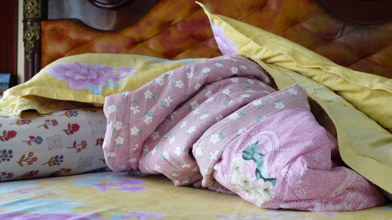 Letto sfatto con cuscini e coperte