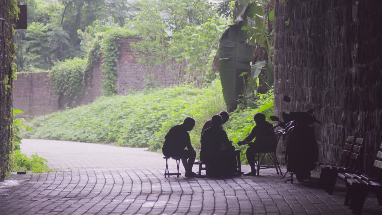 어떤 사람들은 동굴 입구에서 카드놀이를 하고 있다
