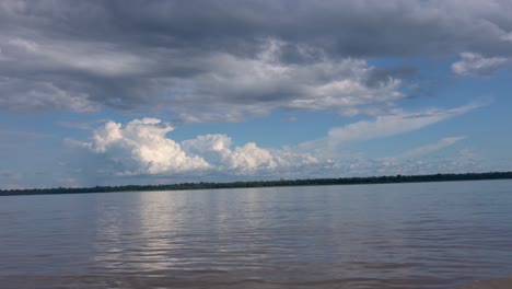 beautiful and serene water at the amazon river on a cloudy day seen from the moving boat