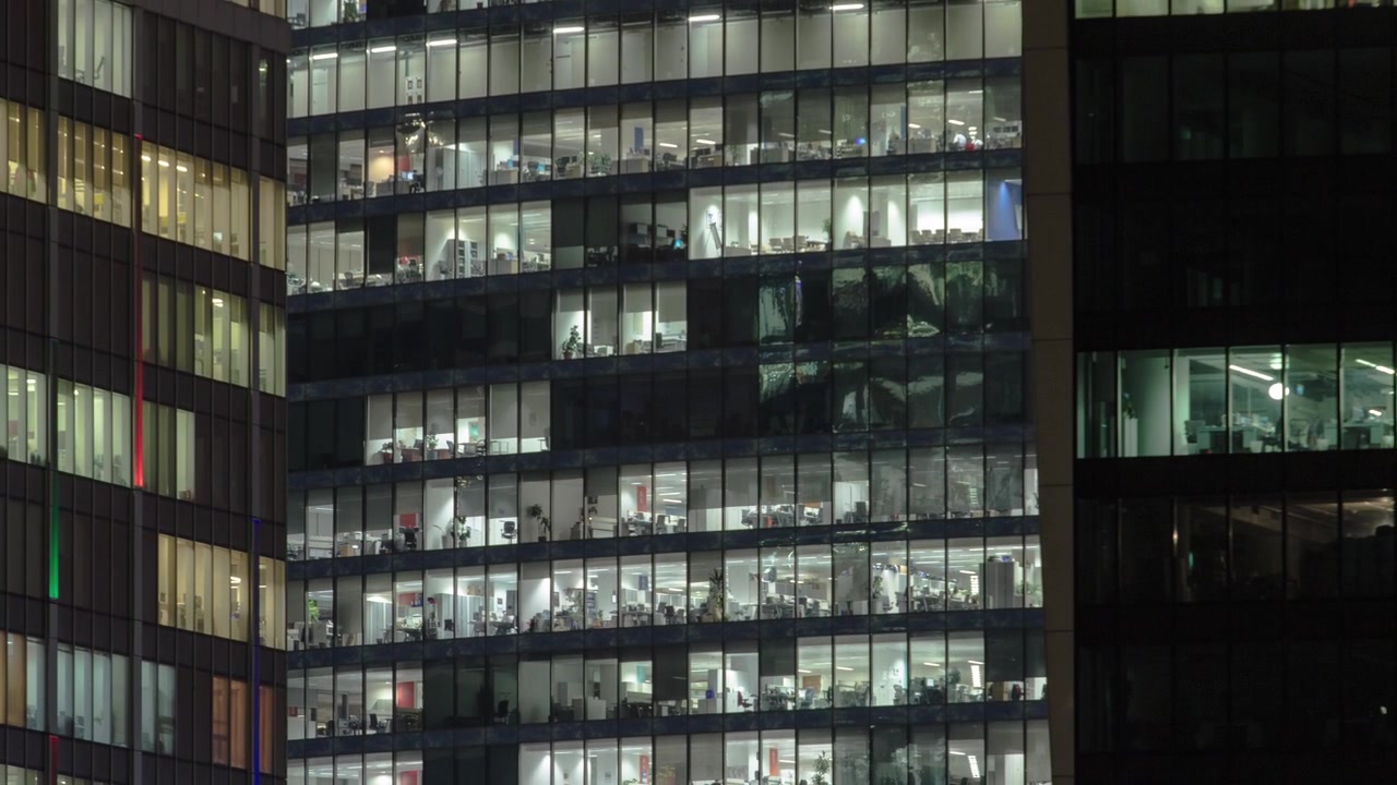 Vista ravvicinata delle finestre degli uffici nei grattacieli del Centro Affari Internazionale della Città di notte timelapse dall'alto