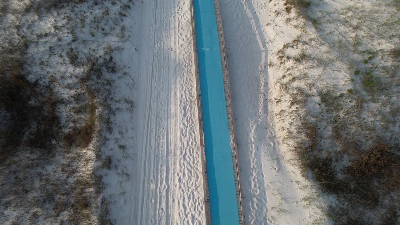 Drone flying over the beach, walk to the white sand beach with emerald waters of the Gulf of Mexico on a bright sunny day