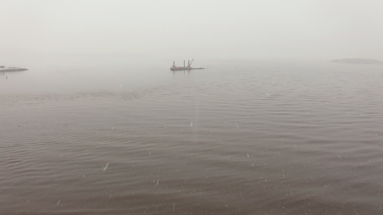 춥고 눈 내리는 겨울날 펀드의 추운 만에 있는 배를 향해 공중을 날고 있다