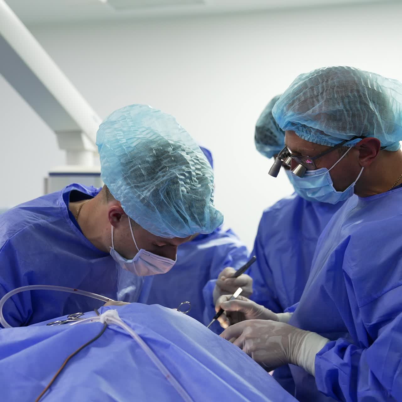 Team of collaborating surgeons performing operation using metal traditional surgery tools. Accurate work of medical professionals at operation