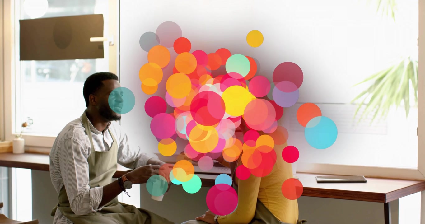 Coffee shop baristas exchanging handshake by window, sparking colorful circles marking greeting