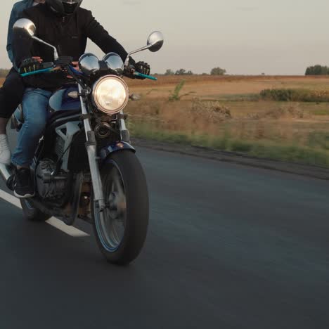 Pareja-Joven-Monta-Una-Motocicleta-En-La-Carretera