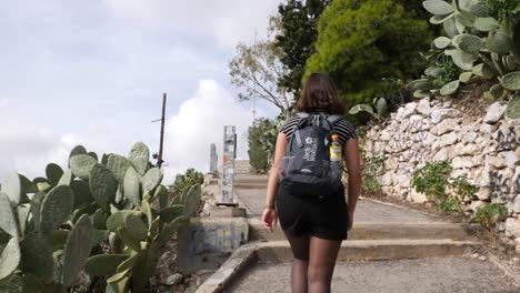 una joven asiática sube por un sendero hacia una montaña en atenas