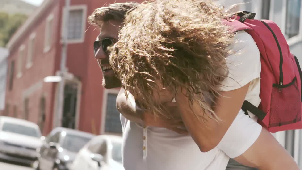 Happy hipster couple doing piggy back