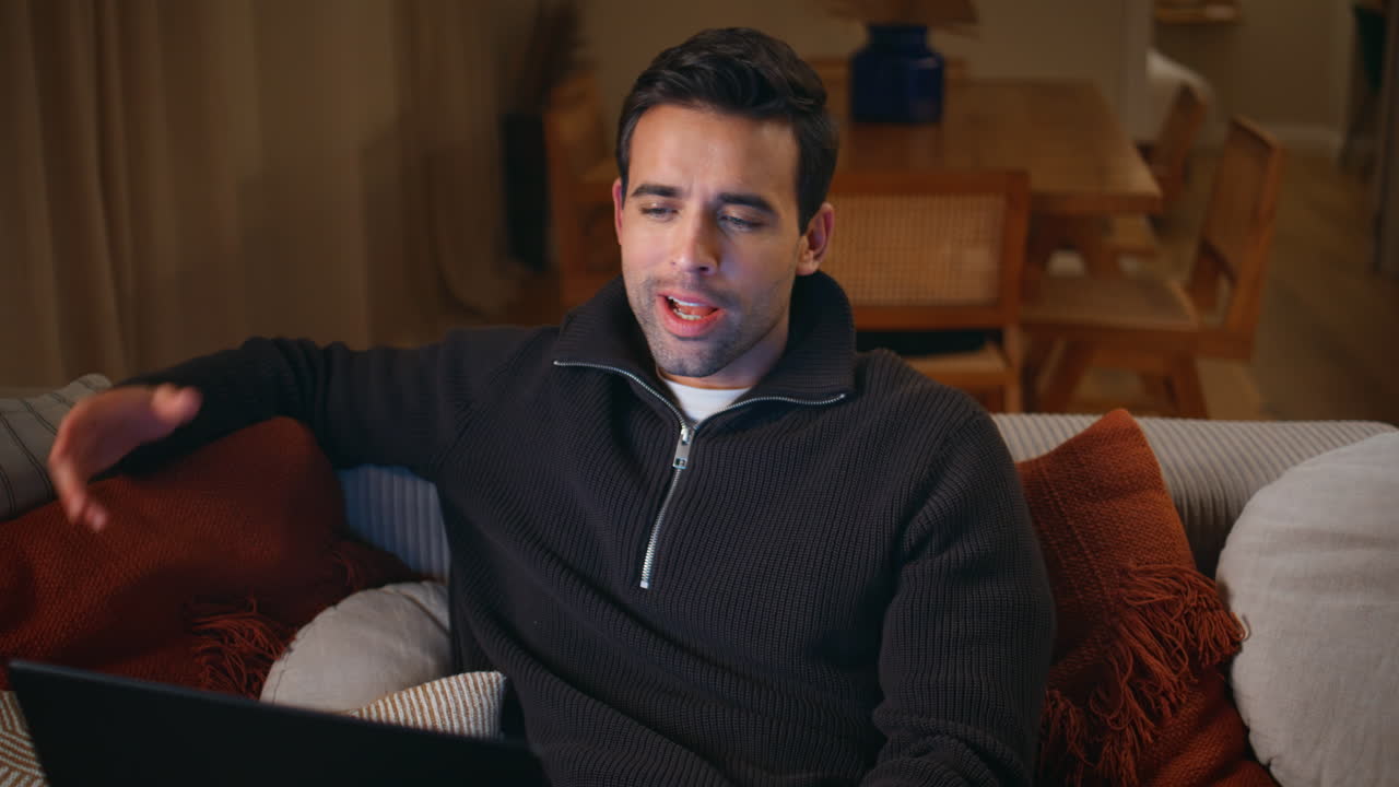 Freelancer discussing work online by laptop virtual chat at home. Smiling man