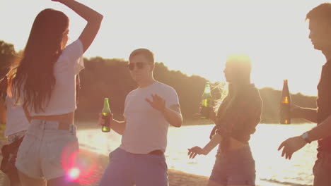 un grupo de mejores amigos bailan y beben cerveza en la fiesta de cumpleaños. es un tiempo despreocupado en la playa al atardecer en la noche de verano.