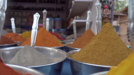 pull back close up through colourful piles of mixed herbs - spices in outdoor store market scene