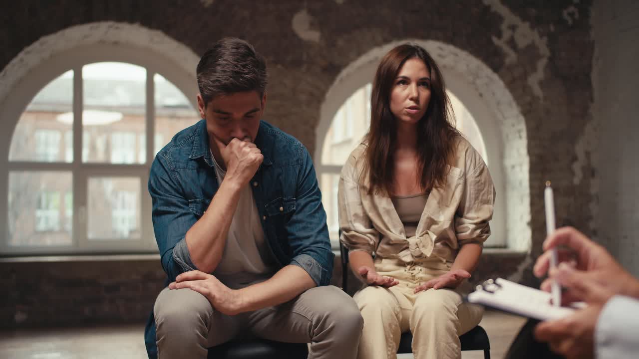 una chica morena cansada habla de sus problemas de vivir en pareja con un chico moreno que es considerado y sostiene su mano a