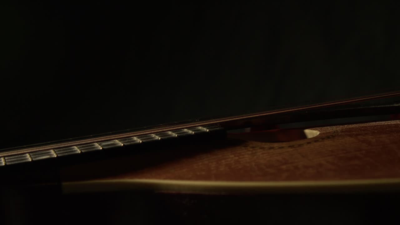 Mandolino vintage ben usato che ruota su sfondo scuro, primo piano