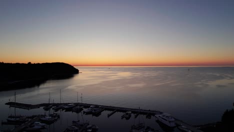 Panning-to-the-left-drone-shot-of-sunset-in-Sister-Bay,-Wisconsin-golden-hour