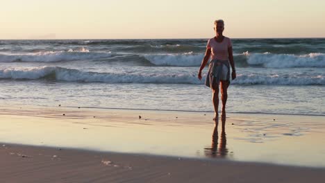 senior woman walking on beach