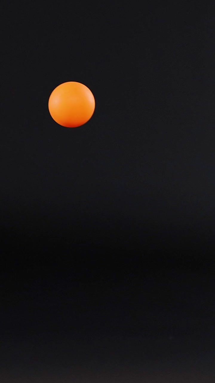 Orange ball bouncing against a dark background