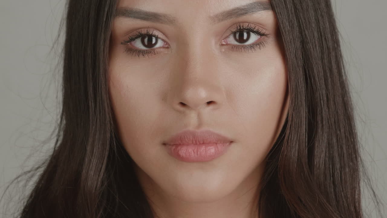 High-quality 4K studio shots of two diverse young women. Focused on face and eyes against a simple grey background. Excellent for beauty, cosmetic, identity, and health advertising