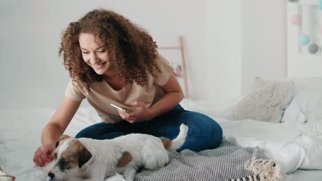 teenage girl having fun with her dog in bedroom