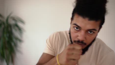 close up of good-looking active mixed race man which training in boxing punches during home workout