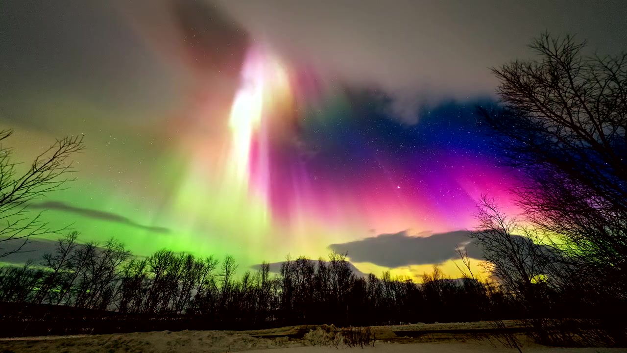 Fargerikt nordlys danser på Finlands stjernehimmel på landsbygda. Timelapse.