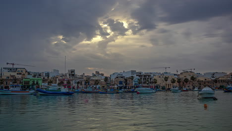 Marsaxlokk-fishing-bay-timelapse,-colored-fishing-boats-in-harbour-port-with-ships,-Malta-island