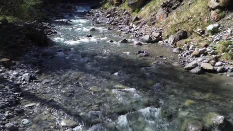 top view of drone fly towards mountain river in austrian nature