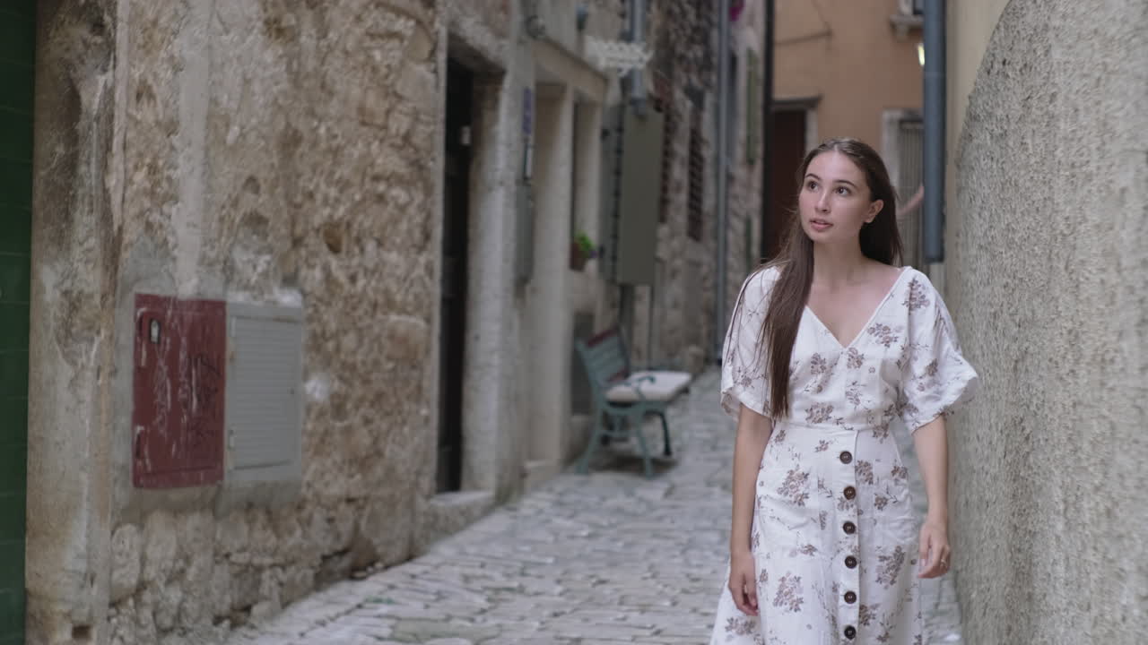 매력적인 옛 마을 골목길을 고 있는 여자