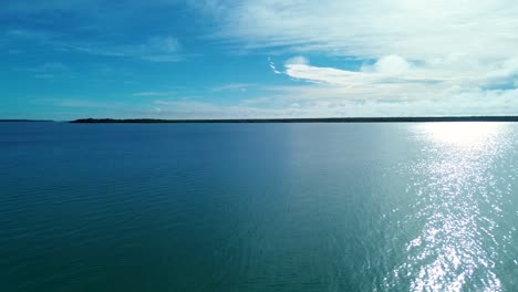 drone aerial landscape of tour boats ferry barge parked at resort wharf jetty boardwalk pier in bacalar lagoon lake with clouds in sky mexico travel boating cruises tourism