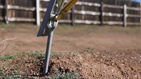 electrical-distribution-utility-ground-anchor-with-a-guy-guard-in-the-morning-golden-hour-light-and-dark-shadows-with-a-fence-row-in-the-background