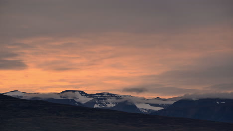 Fiery-cloudy-sunset-time-lapse-above-mountains