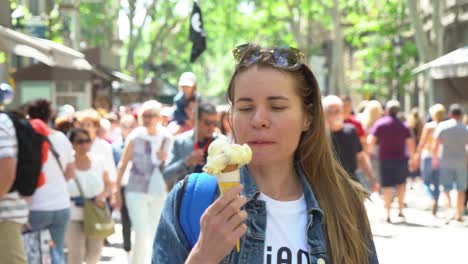 barcelona, spain. a girl is walking down the street eating an ice cream