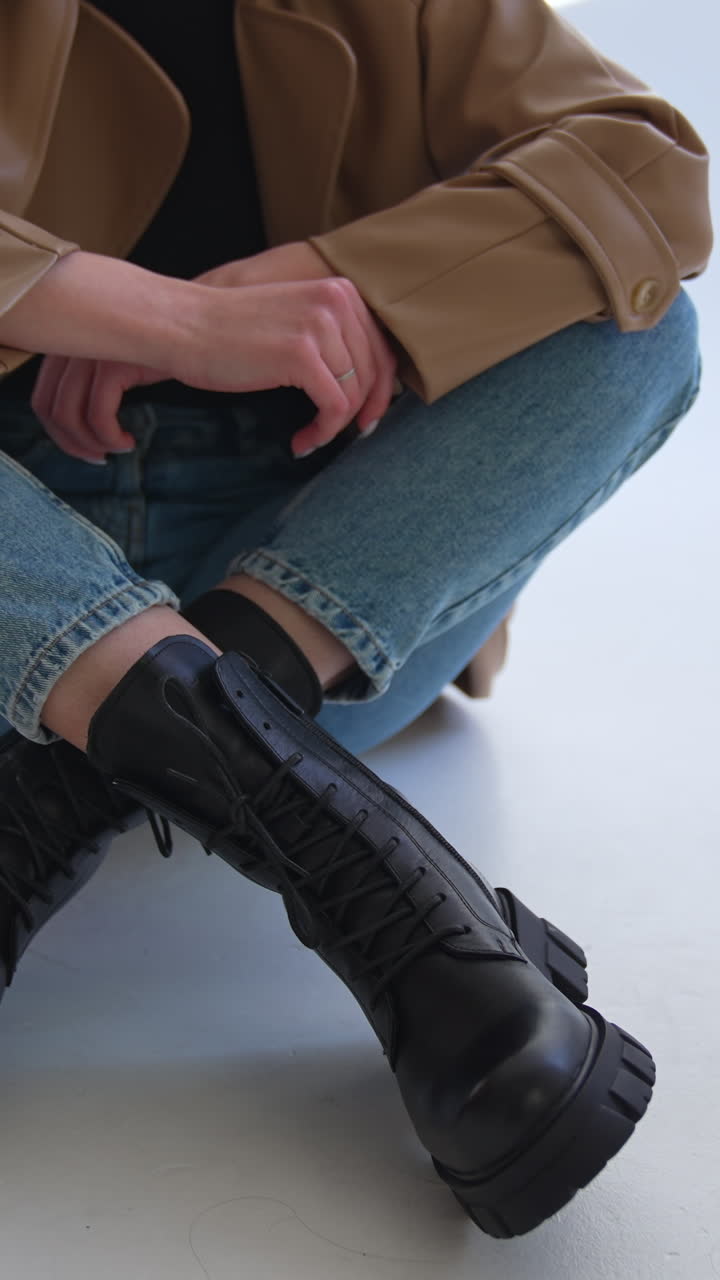 Woman wearing black leather boots and blue jeans