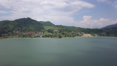toma aérea de aumento lento del lago - embalse con cordillera en el fondo